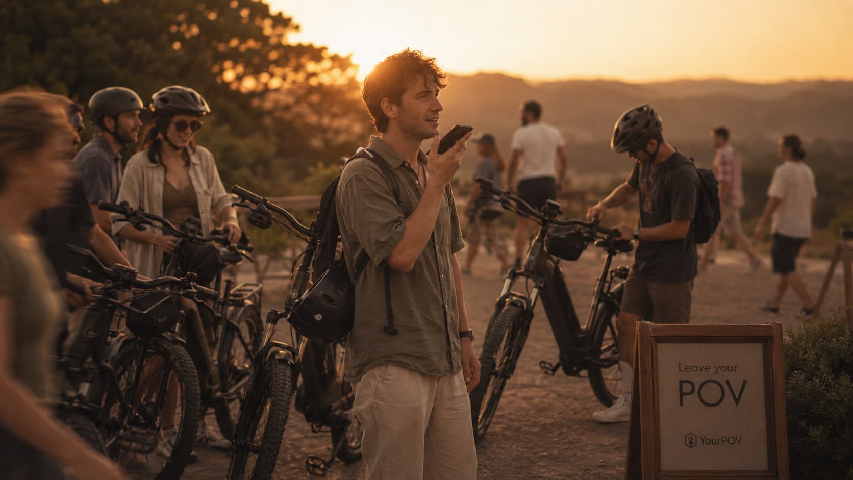 Cyclists pausing at sunset while one leaves a spoken response on their phone